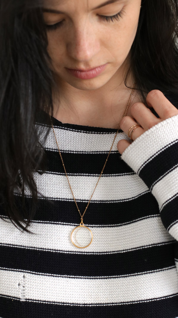 Schema  Gold-plated resin pendant with a lock of baby's hair