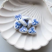 Ceramic heart bead 15x14.5 mm - bow motif - White - Blue x1
