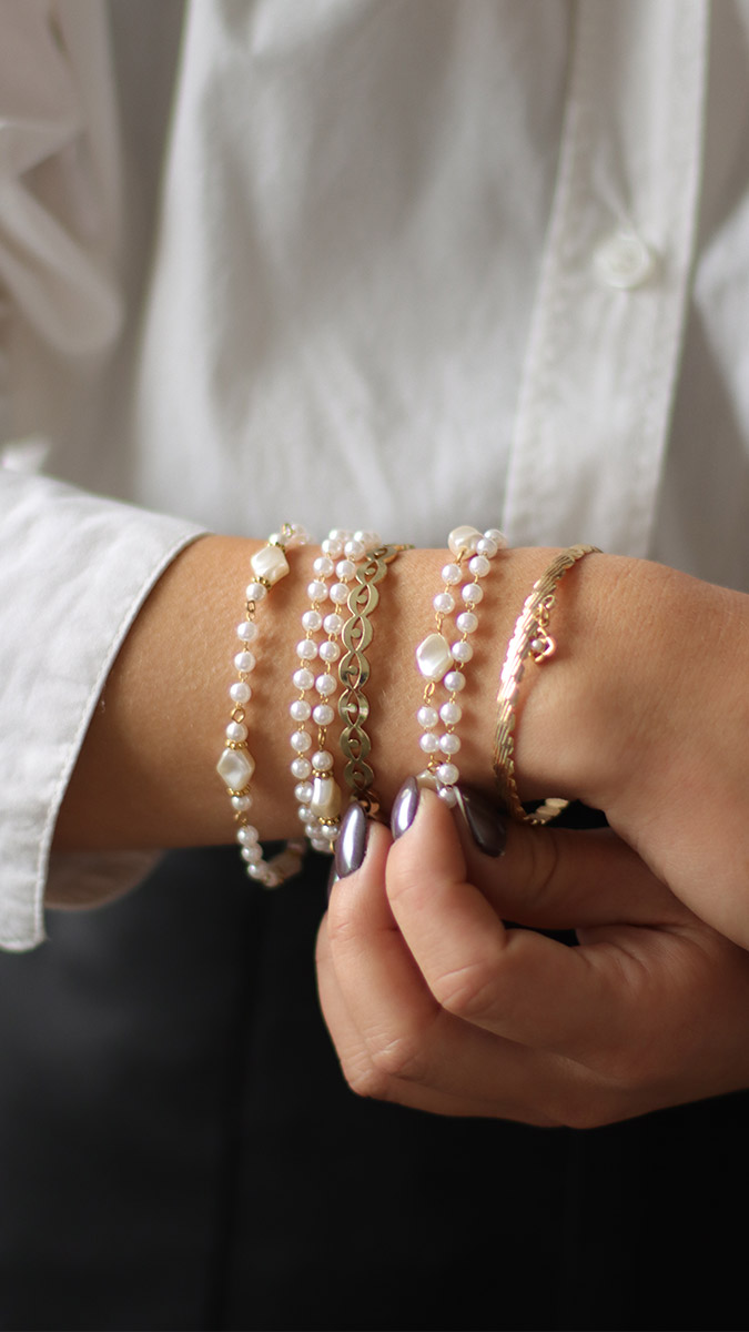 Stacking of gold-plated Manon bracelets and imitation mother-of-pearl pearls