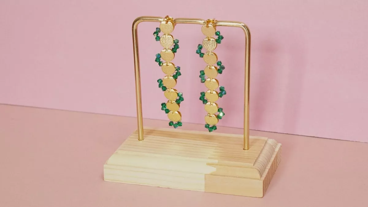 Long gold earrings with green crystal spinning tops Long gold earrings with green crystal spinning tops