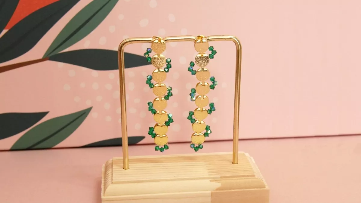 Schema  Long gold earrings with green crystal spinning tops